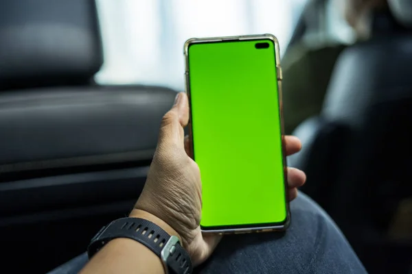 남성 승객이 녹색 화면이 있는 휴대폰을 들고 있습니다. — 스톡 사진