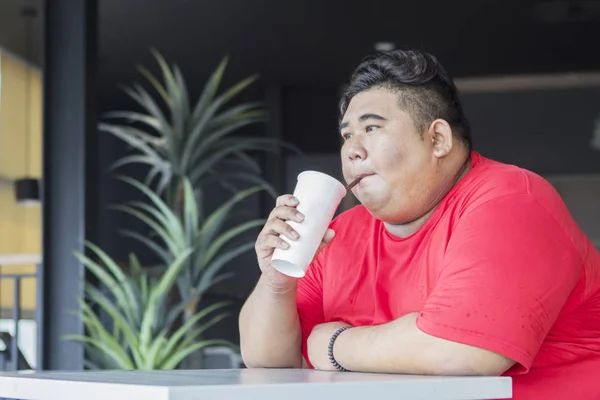 Jovem gordo bebendo um copo de cola no café — Fotografia de Stock