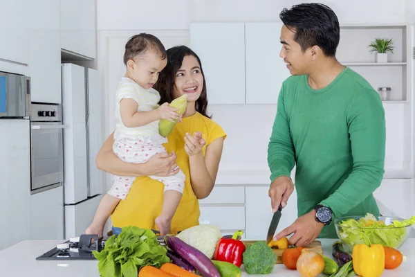 Jeune homme cuisine avec sa femme et sa fille — Photo