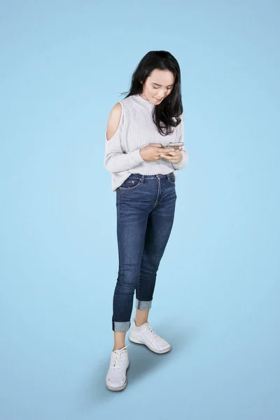 Молода жінка смс на мобільному телефоні — стокове фото