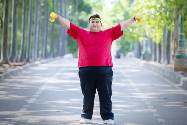 Obez adam parkta dambıl ile egzersiz — Stok fotoğraf