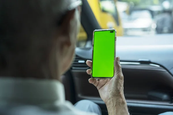 Vieil homme tient un téléphone avec écran blanc dans la voiture — Photo