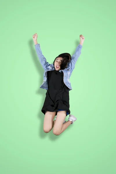 Bella ragazza che celebra il successo saltando in studio — Foto Stock