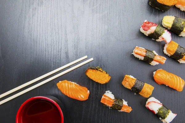 Varios nigiri sushi con palillos en la mesa — Foto de Stock
