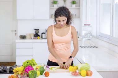 Sağlıklı bir salata hazırlayan kıvırcık saçlı kadın