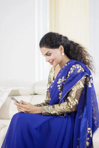Hermosa mujer india usando un teléfono en casa — Foto de Stock