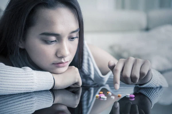 Drugs verslaafde meisje tellen geneeskunde op de tafel — Stockfoto