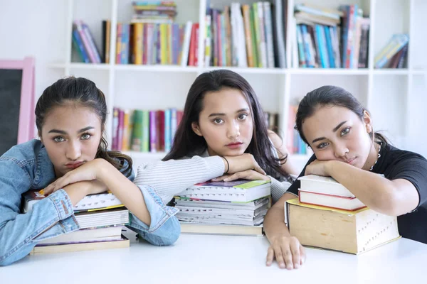 Vrouwelijke studenten kijken verveeld in de bibliotheek — Stockfoto