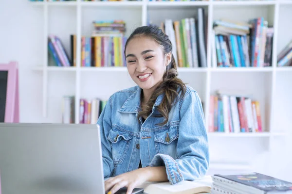 Női tinédzser tanul a laptop a könyvtárban — Stock Fotó