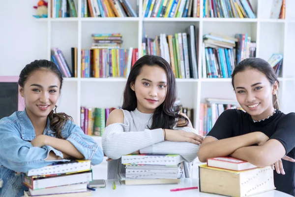 Group of pretty teenagers studying in the library — Stock Photo, Image