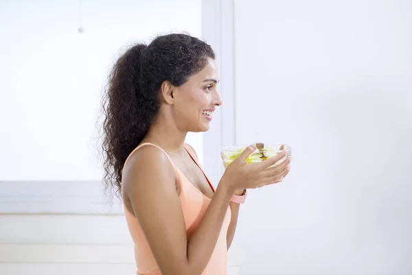 Femme souriante tenant un bol de salade de légumes — Photo