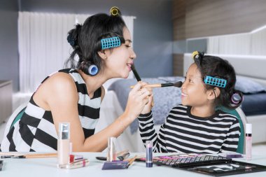 Anne ve çocuk birbirlerine makyaj yapıyorlar.