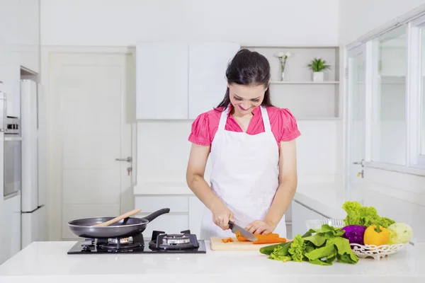 Mulher branca cortando legumes na cozinha — Fotografia de Stock