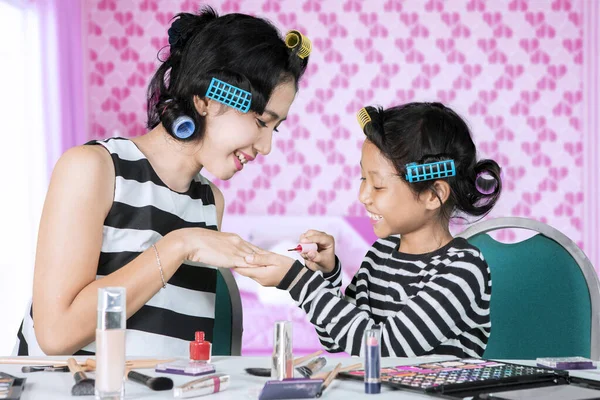 Enfant appliquant du vernis à ongles à sa mère dans la chambre — Photo