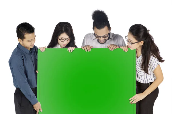 Бизнес-команда смотрит на пустую зеленую доску — стоковое фото
