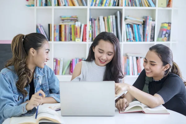 Group of female students using a laptop in library — Stock Photo, Image
