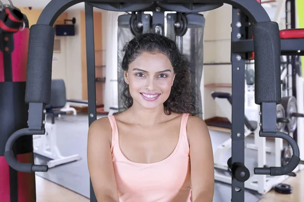 Beautiful Indian woman sits on a fitness machine — Stock Photo, Image