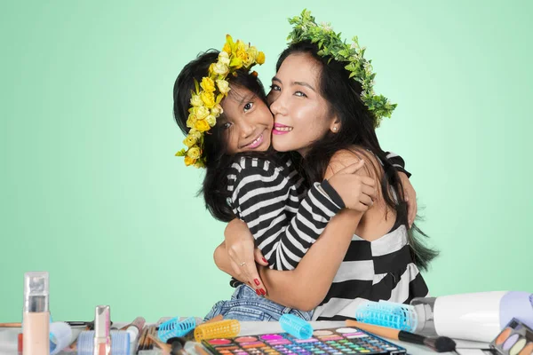 Frau umarmt ihr Kind nach Make-up im Studio — Stockfoto