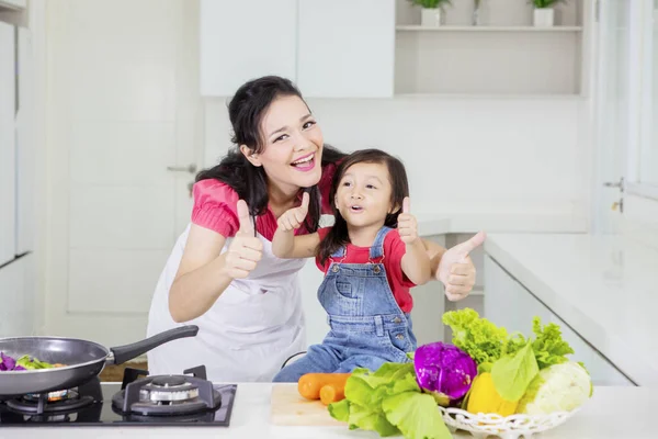 Anne ve çocuk aşçılıktan sonra baş parmağını kaldırır. — Stok fotoğraf