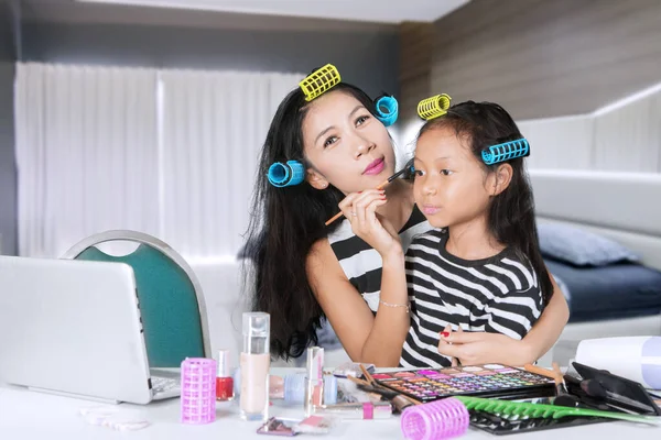 Kobieta robi makijaż z córką w domu — Zdjęcie stockowe