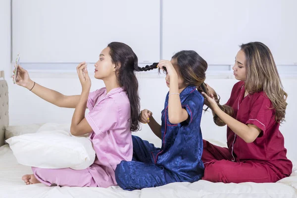 Όμορφα κορίτσια δένουν μαλλιά το ένα στο άλλο και σέλφι φωτογραφία — Φωτογραφία Αρχείου