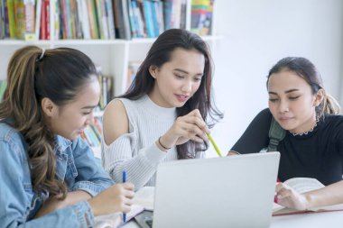 Bir grup kız öğrenci kütüphanede okuyor. 