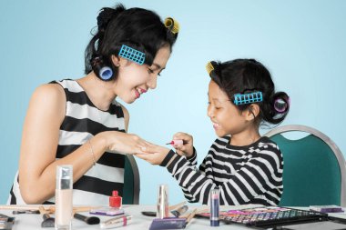 Stüdyoda annesine oje süren bir kız.