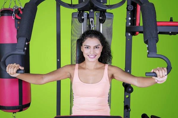 stock image Sporty woman with a fitness machine on studio