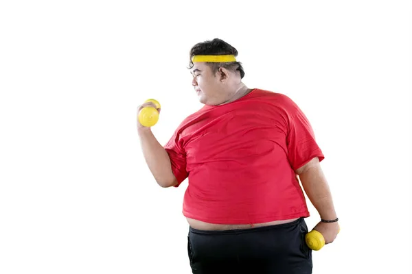 Jovem obeso homem exercício com halteres no estúdio — Fotografia de Stock