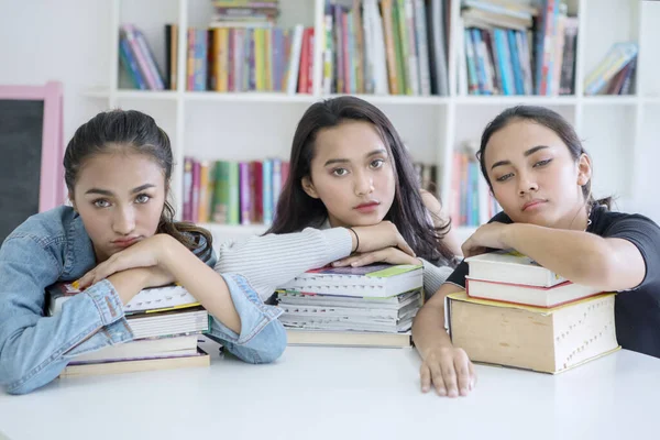 Groep tiener meisjes kijkt verveeld in de bibliotheek — Stockfoto