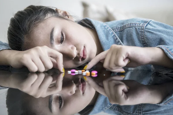 Adolescente feminina parece deprimida contando drogas — Fotografia de Stock