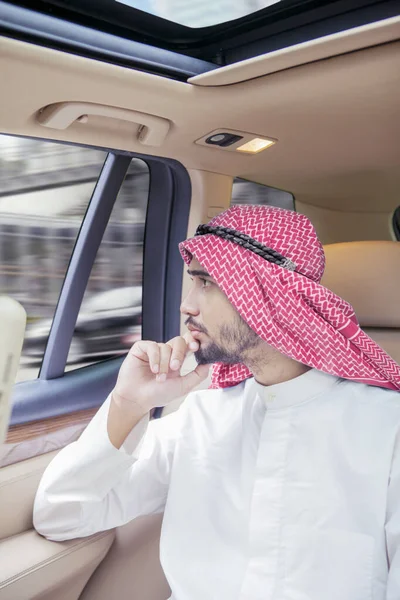 Arabisk affärsman tittar ut genom bilfönstret — Stockfoto