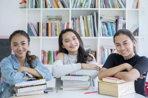Happy teenager girls studying in the library — Stock Photo, Image