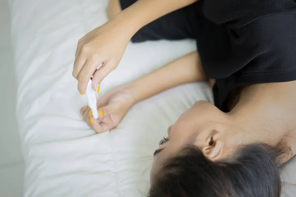 Gefrustreerd tienermeisje met zwangerschapstest in bed — Stockfoto
