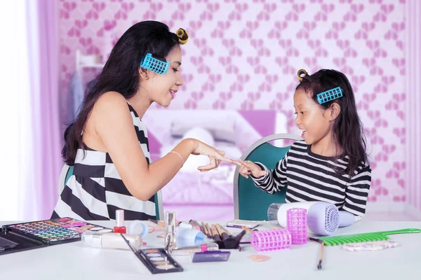 Chica divirtiéndose con la madre mientras hace maquillaje —  Fotos de Stock