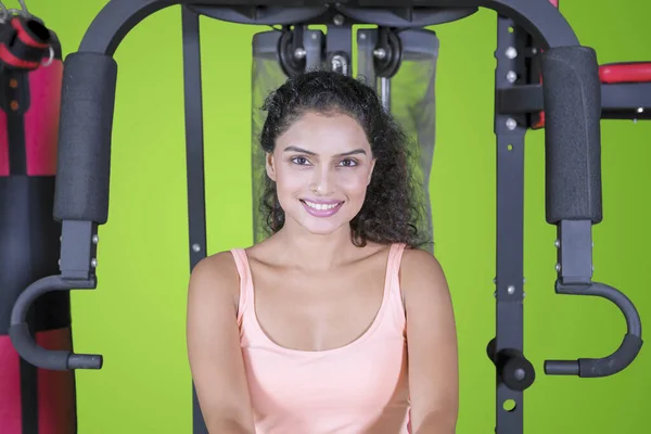 Pretty Indian woman sits on a fitness machine — Stock Photo, Image