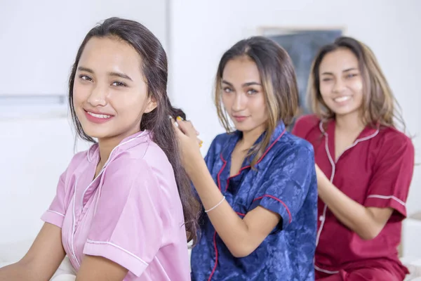 Група красивих дівчат-підлітків зв'язують волосся один з одним — стокове фото
