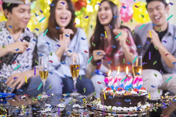 幸せな人々を背景にぼやけた誕生日ケーキ — ストック写真