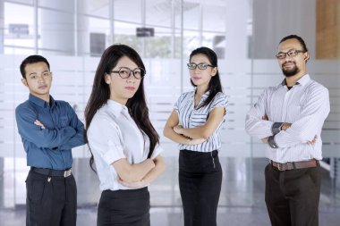 Bir grup iş adamı ofiste kendinden emin görünüyorlar.