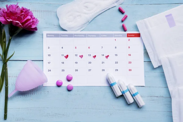 Calendario con productos de higiene femenina en la mesa — Foto de Stock