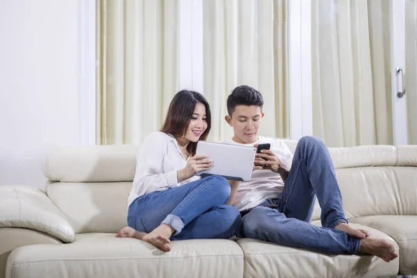 Pareja disfrutando del tiempo libre con tableta y teléfono — Foto de Stock