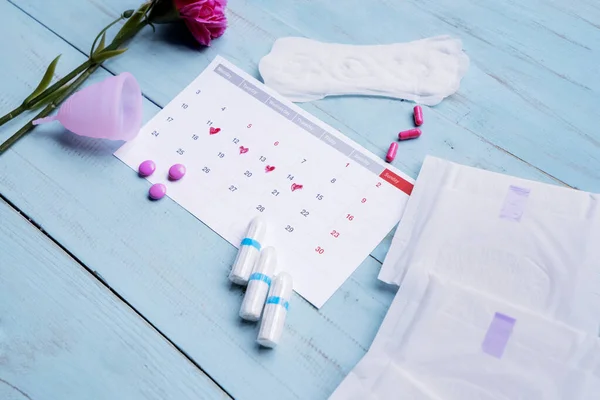 Vrouwelijke hygiëneproducten met kalender op tafel — Stockfoto