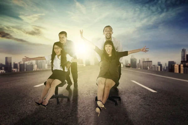 Group of business people racing on chairs at outdoor — Stock Photo, Image