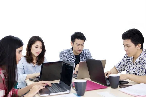 Gruppo di giovani dipendenti sembra occupato in studio — Foto Stock