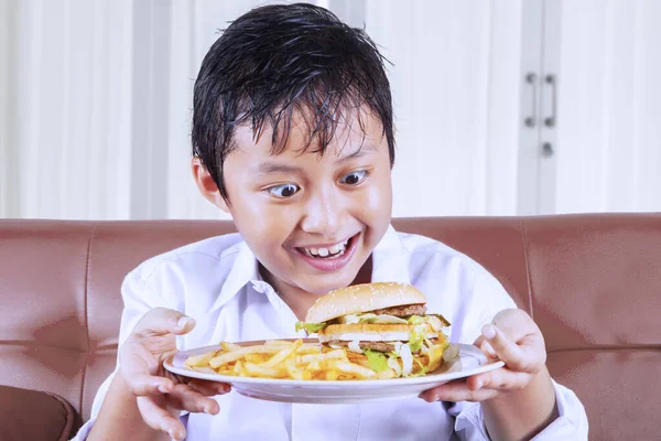 El niño tiene un gran deseo de comer comida chatarra. — Foto de Stock