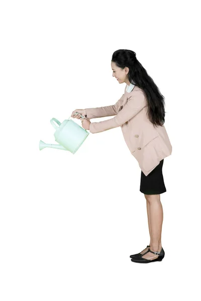 Pretty entrepreneur using a watering can on studio — Stock Photo, Image