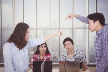 Takım toplantısında birbirini suçlayan iki işçi.