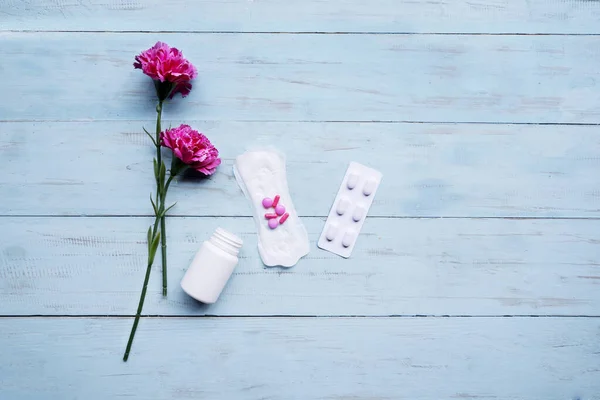 Tappetino sanitario con pillole e rose sul tavolo — Foto Stock