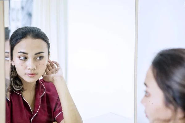 Teenage girl examining her pimples in the mirror — ストック写真