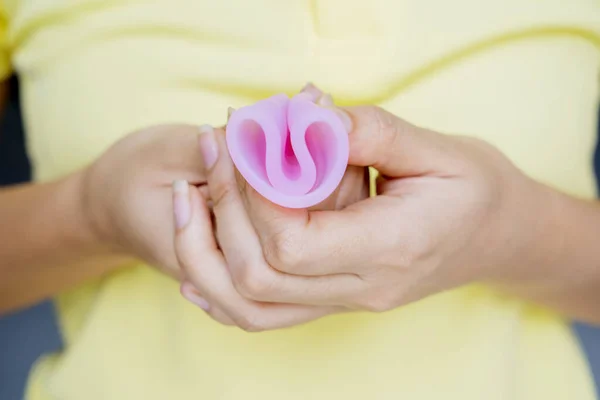 Desconhecido mulher mãos dobrar um copo menstrual — Fotografia de Stock